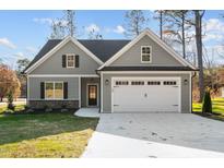 Charming home featuring a two-car garage, stone accents, and a well-maintained lawn at 100 Carol Cir # 17, Louisburg, NC 27549