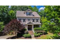Charming two-story home with landscaped yard, flowering tree, and covered entry featuring beautiful decorative wreaths at 101 Eden Glen Dr, Holly Springs, NC 27540