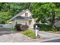 Charming yellow home featuring a manicured front yard, driveway, and lush trees at 102 Legacy Ln, Durham, NC 27713