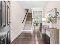 Inviting entryway with hardwood floors, staircase, decor table, and access to the living areas with bright natural light at 1049 Lakebrink Dr, Morrisville, NC 27560