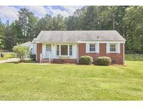 Charming brick home with a well-maintained lawn and mature trees at 1105 Horseshoe Rd, Durham, NC 27703