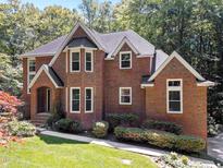 Charming brick home featuring a well-manicured lawn and beautiful landscaping at 11425 Horsemans Trl, Raleigh, NC 27613