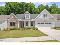 Charming home with a stone facade, manicured lawn, and inviting front entrance at 131 English Violet Ln, Raleigh, NC 27610