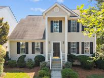 Charming two-story home featuring a covered entry, dark shutters, and well-maintained landscaping at 148 Danesway Dr, Holly Springs, NC 27540