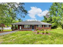 Charming brick home with a covered carport and well-maintained front yard, exuding curb appeal at 1592 Boone Rd, Elon, NC 27244
