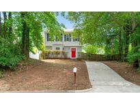 Charming two-story home featuring a bright red front door, blue shutters, and a well-manicured front yard at 2309 Hoot Owl Ct, Raleigh, NC 27603