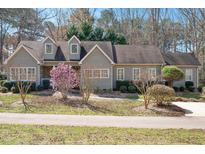 Charming single-story home with a manicured lawn, flowering trees, and gray siding at 2412 Mollynick Lane Ln, Wake Forest, NC 27587