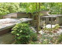 Contemporary home featuring a flat roof, complemented by beautiful landscaping and natural wooded surroundings at 2713 Mcdowell Rd, Durham, NC 27705