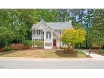 Charming two-story home featuring a red door and a well-manicured lawn at 3008 Isabella Dr, Raleigh, NC 27603