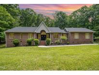 Charming one-story brick home with beautiful landscaping and a well-manicured lawn at 313 Shetland Rd, Rougemont, NC 27572
