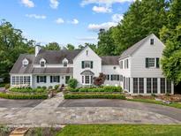 Beautiful white home with lush landscaping and a stone driveway, offering a grand and inviting curb appeal at 3816 Dover Rd, Durham, NC 27707