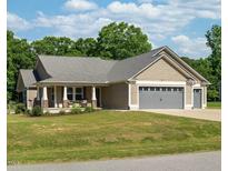 Charming tan home with a two car garage and a rocking chair front porch at 50 Viajar Way, Smithfield, NC 27577