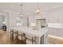 Bright, spacious kitchen with large marble island, pendant lighting, and stainless steel appliances at 5308 Montclair Dr, Raleigh, NC 27609