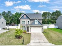 Charming two-story home featuring a well-manicured lawn, lovely curb appeal, and an attached two-car garage at 5412 Emerald Spring Dr, Knightdale, NC 27545