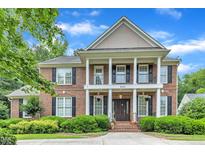 Stunning brick home boasts a grand entrance, manicured landscaping, and a charming two-story facade at 5521 Erinvale Ct, Holly Springs, NC 27540