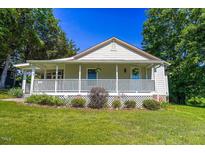 Charming single-story home with a inviting front porch, landscaped yard, and lots of shade trees at 5625 Church Rd, Graham, NC 27253