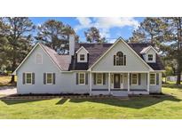 Charming two-story home with light blue siding, dark shutters and a landscaped front yard at 620 Richardson Rd, Zebulon, NC 27597