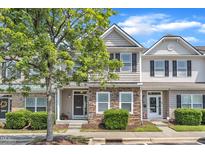 Charming townhome with stone accents, manicured bushes, and a tree-lined street at 711 Keystone Park Dr # 7, Morrisville, NC 27560