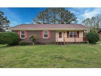 Charming brick home with a well-maintained lawn and mature trees on a sunny day at 713 Marlboro Pl, Rocky Mount, NC 27801