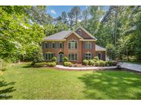 Charming two-story brick home with a manicured lawn and lush landscaping at 8840 Woodyhill Rd, Raleigh, NC 27613