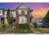 Charming two-story townhome with brick facade, manicured lawn, and inviting front steps at 100 Stratford Lakes # 130, Durham, NC 27713