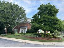 Charming brick home featuring meticulously manicured front yard and mature trees at 12221 Orchardgrass Ln, Raleigh, NC 27614