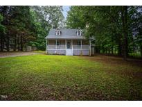 Charming home featuring a welcoming front porch and well-maintained lawn surrounded by mature trees at 129 Clark Ct, Youngsville, NC 27596