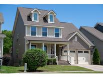 Charming two-story home with a welcoming front porch and attached two-car garage at 1600 Drift Falls Ln, Wendell, NC 27591