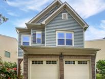 Charming two-story home with a stone-clad garage and blue horizontal siding at 2072 Tanners Mill Dr, Durham, NC 27703