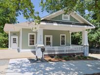 Charming exterior featuring a cozy porch, white railing, and manicured landscaping at 2106 University Dr, Durham, NC 27707