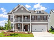 Charming two-story home boasts a covered porch, two-car garage, and manicured lawn at 2178 Pink Peony Circle Lot 167 Cir, Durham, NC 27703