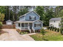 Charming two-story home boasts a welcoming front porch, complemented by verdant landscaping and natural surroundings at 225 Sacred Fire Rd, Louisburg, NC 27549