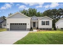 Charming single-story home featuring a grey garage, blue shutters, and a well-manicured lawn at 235 Eason Creek Way, Clayton, NC 27527