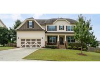 Charming two-story home with a covered porch, manicured lawn, and attached two-car garage at 453 Granite Saddle Dr, Rolesville, NC 27571