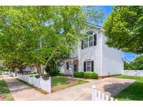Charming two-story home with white siding, black shutters, and a well-manicured front yard and a white picket fence at 5016 Dawn Piper Dr, Raleigh, NC 27613