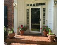 Inviting entryway with brick steps and potted plants at front door with sidelight windows at 511 Windstream Way, Cary, NC 27518