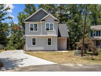 Charming two-story home with gray siding, dark roof, and a concrete driveway surrounded by lush greenery at 5601 Preston Pl, Raleigh, NC 27604