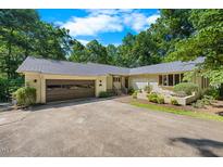 Lovely exterior view of home featuring an attached two-car garage, brick facade, and mature landscaping at 5822 Country Lane Dr, Durham, NC 27705