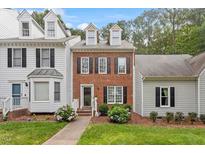Charming brick townhome with manicured lawn and inviting walkway at 6032 Epping Forest Dr, Raleigh, NC 27613