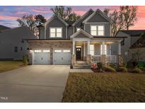 Charming two-story home with stone accents, a welcoming front porch, and a two-car garage at 604 Craftsman Ridge Trail Trl, Knightdale, NC 27545