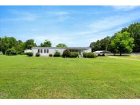 Sprawling front yard and exterior view of a single story home with covered parking at 70 Fieldside Dr, Louisburg, NC 27549