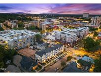 Night aerial view of stylish townhouses in an urban setting, showcasing the neighborhood's vibrant atmosphere at 710 W North St # 102, Raleigh, NC 27603