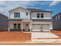 New two-story home boasts a two-car garage, white siding, and brick foundation on a spacious, unfinished lot at 740 Deschutes Dr, Garner, NC 27529