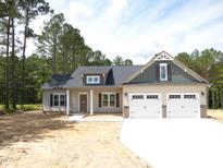 Charming home featuring a two-car garage, a welcoming entrance, and a well-manicured front yard at 802 Shade Tree Rd, Benson, NC 27504