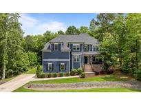 Charming two-story home with a manicured lawn and mature trees offering shade and curb appeal at 8304 Southmoor Hill Trl, Wake Forest, NC 27587