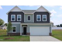 Two-story home featuring a two-car garage, modern siding, and a well-manicured lawn at 956 Bombardier Ln, Spring Hope, NC 27882
