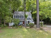 Charming two-story home with light blue siding, black shutters, and lush landscaping at 103 Oxford Cir, Knightdale, NC 27545