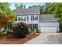 Charming two-story home with a manicured lawn, a two-car garage, and an inviting blue facade at 104 S Crabtree Knl, Chapel Hill, NC 27514