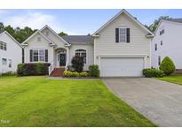 Charming home featuring a well-manicured lawn, two-car garage, and beautiful landscaping at 107 Governors House Dr, Morrisville, NC 27560