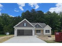 Charming single-story home featuring a two-car garage and stylish architectural details at 109 Drew St, Louisburg, NC 27549